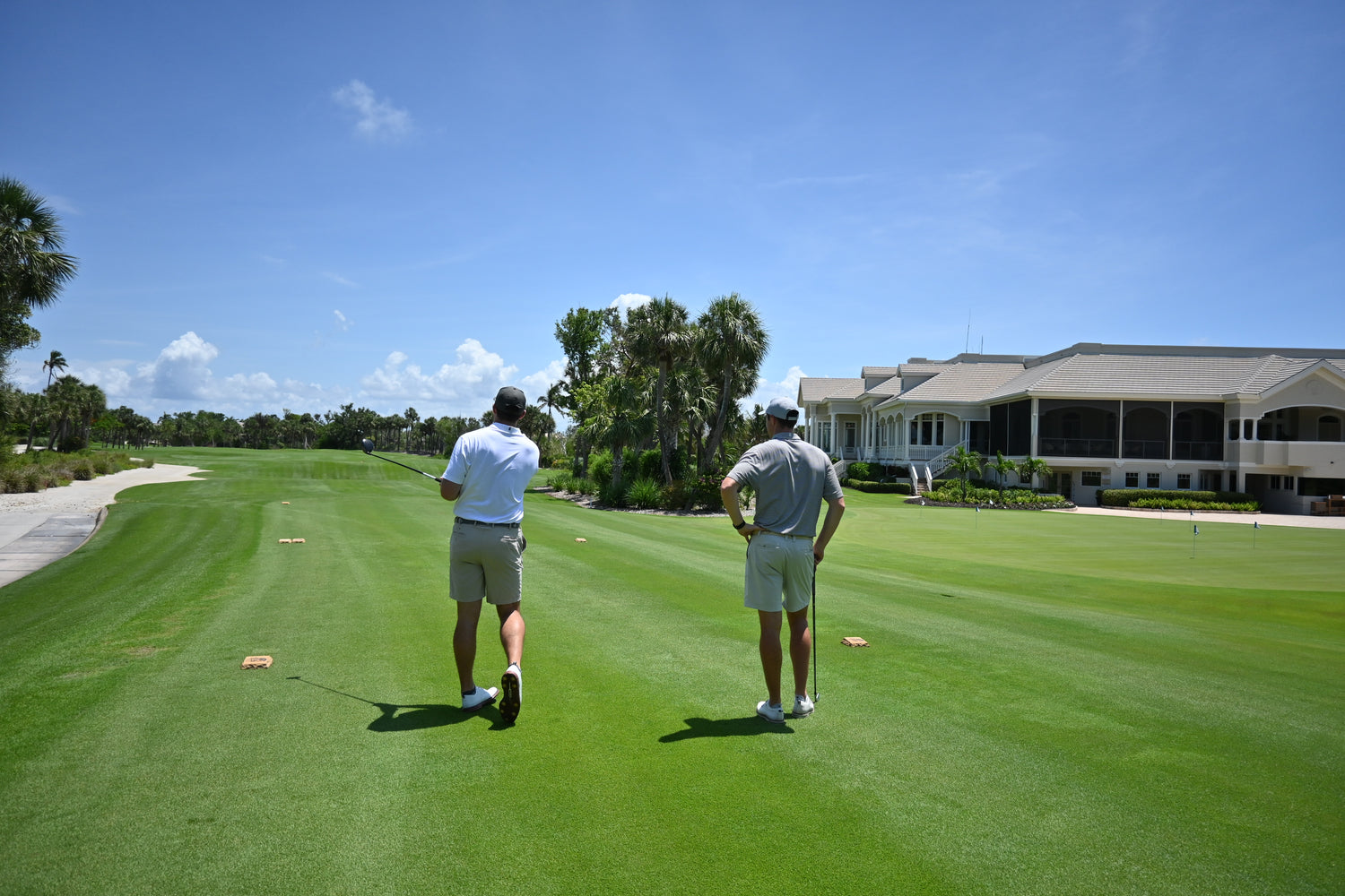 Two golf discussing their shot decisions while wearing their eco-friendly golf shirts