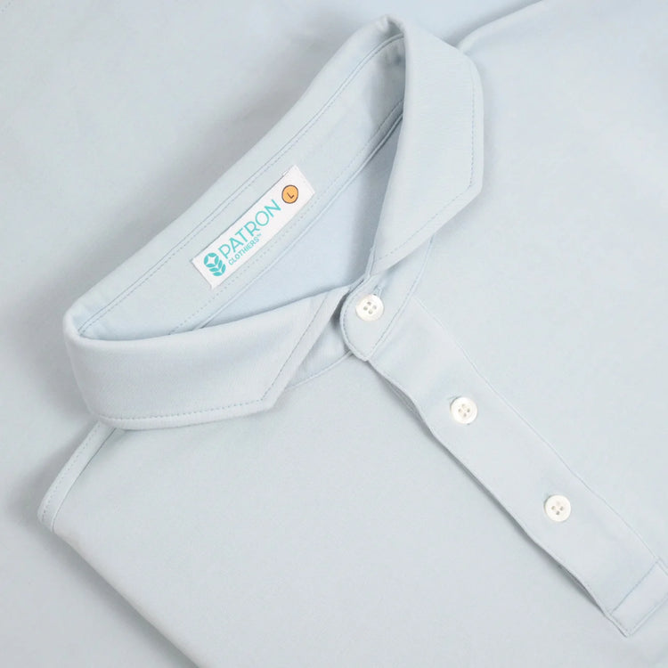Light blue close-up of Patron polo cutaway collar and button detail